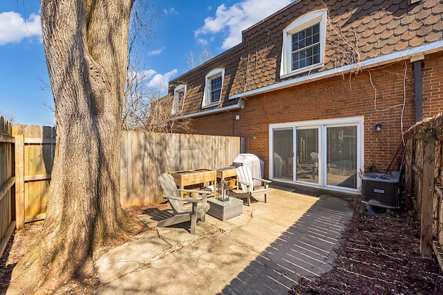 view of patio / terrace with central air condition unit and a fenced backyard