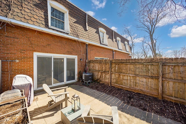 view of patio featuring central AC unit and fence