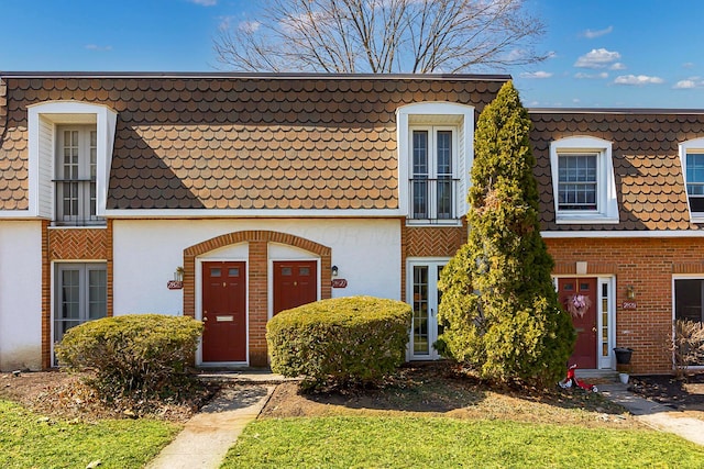 multi unit property with mansard roof and brick siding