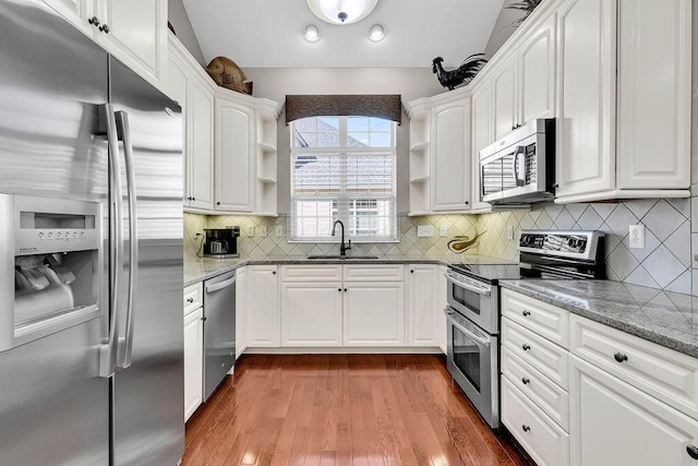 kitchen featuring a sink, white cabinets, appliances with stainless steel finishes, and open shelves