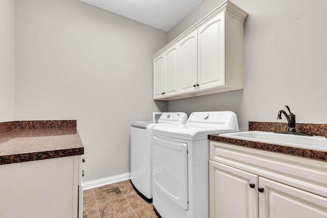 laundry area featuring washer and clothes dryer, cabinet space, baseboards, and a sink