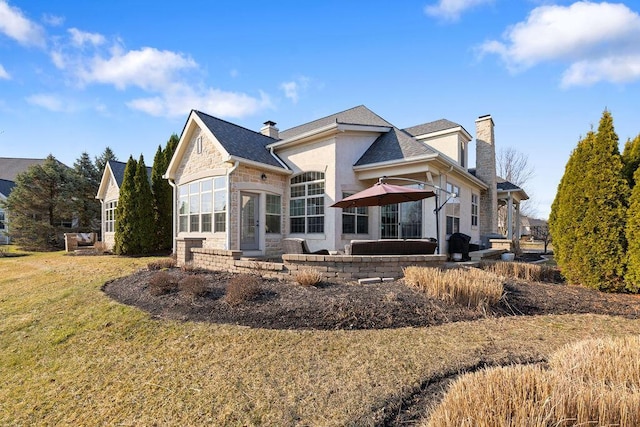 back of property with a shingled roof, a lawn, and a chimney