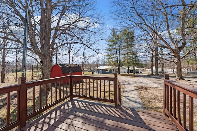 wooden deck with an outbuilding and a storage shed