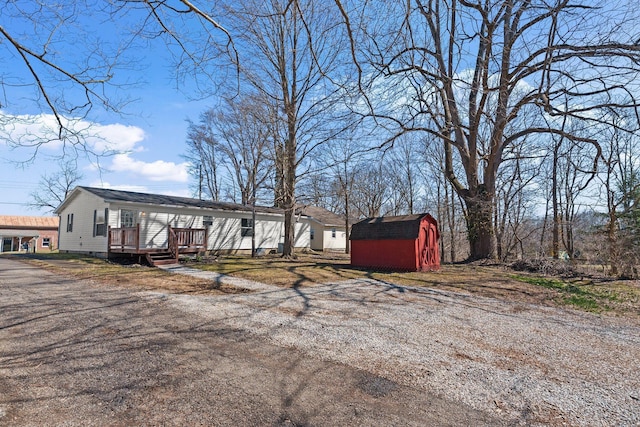 view of front of house with a deck, a storage shed, and an outdoor structure