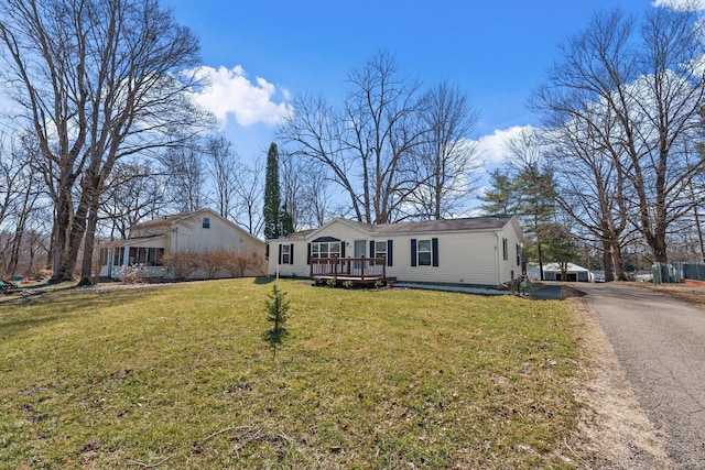 view of front of house with a front yard and a wooden deck