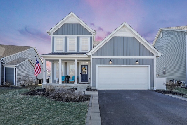 view of front of property with covered porch, board and batten siding, an attached garage, and driveway