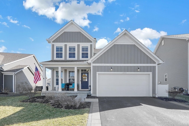 view of front facade with aphalt driveway, board and batten siding, covered porch, and an attached garage