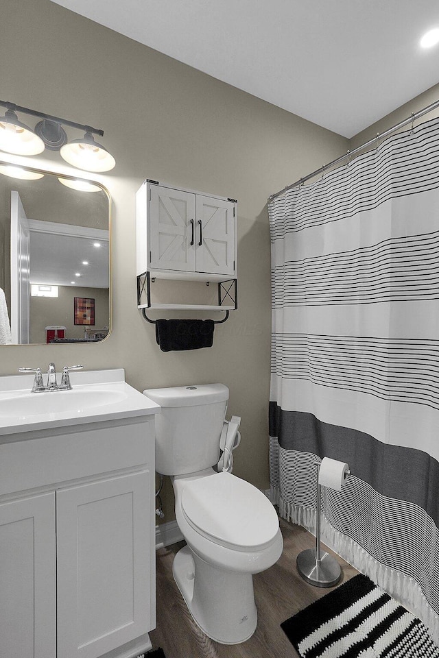 full bath with curtained shower, toilet, wood finished floors, and vanity