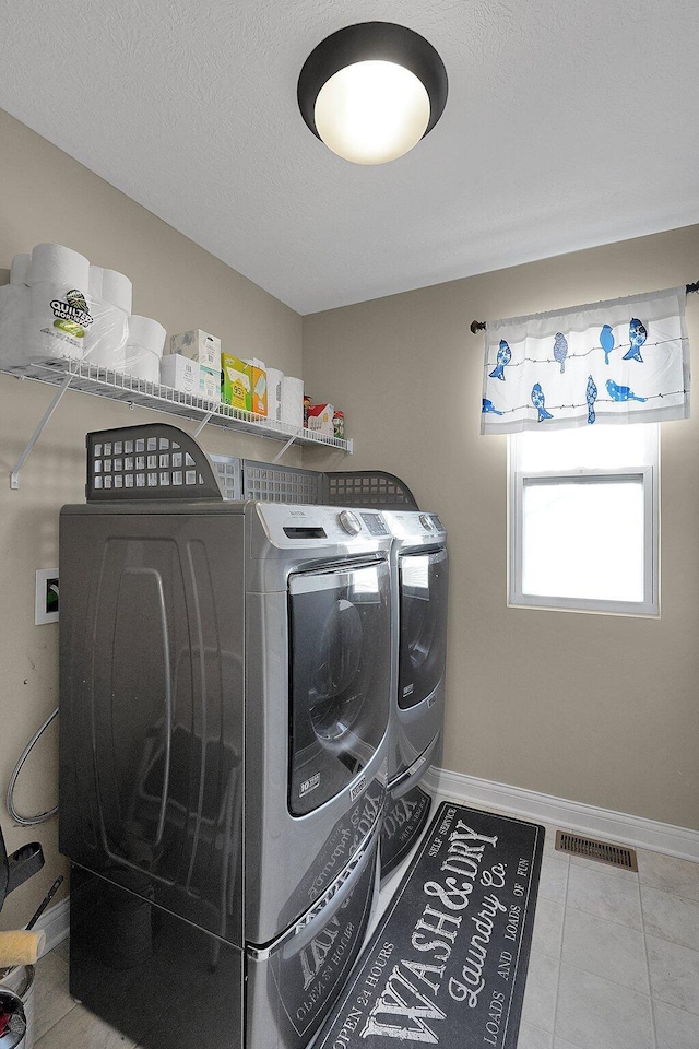 laundry area featuring visible vents, baseboards, separate washer and dryer, and laundry area