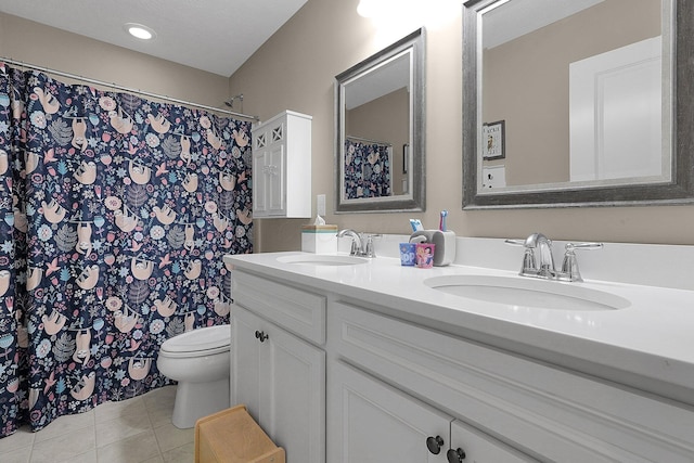 full bathroom with tile patterned floors, toilet, double vanity, and a sink