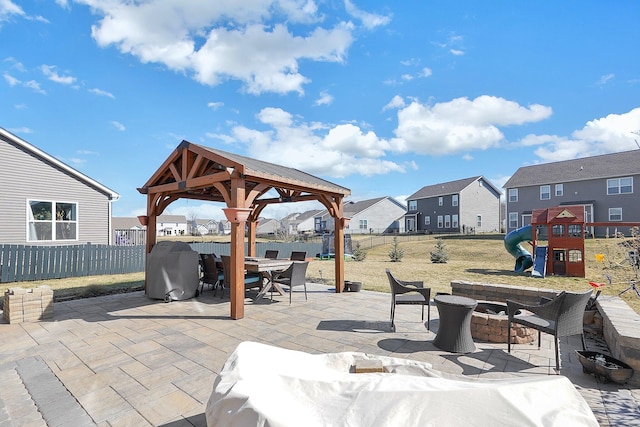 view of patio featuring area for grilling, outdoor dining area, a fenced backyard, a gazebo, and a playground