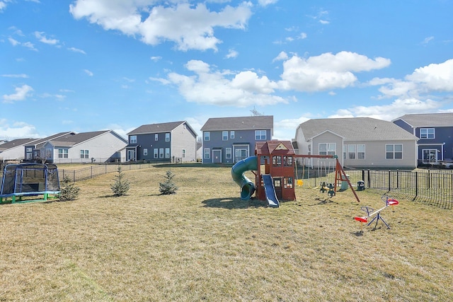 view of jungle gym with a yard, a residential view, a trampoline, and a fenced backyard