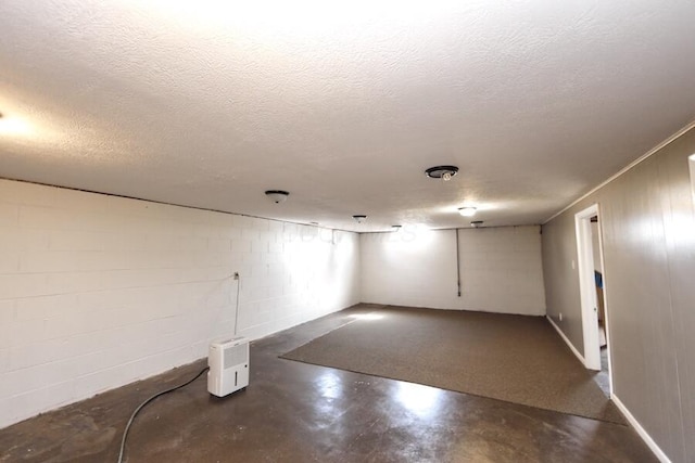 basement with a textured ceiling and concrete block wall