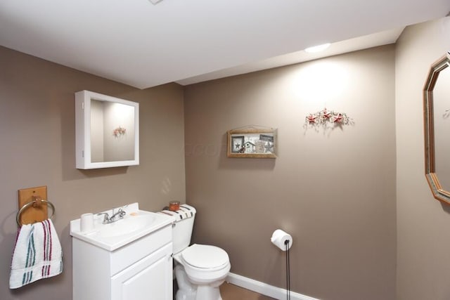 bathroom featuring baseboards, toilet, and vanity