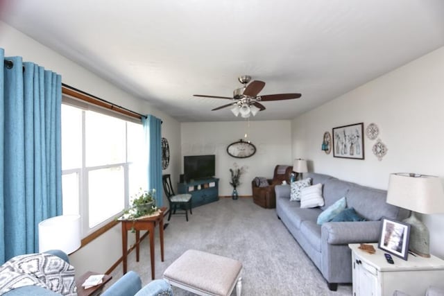 living area with light colored carpet and a ceiling fan