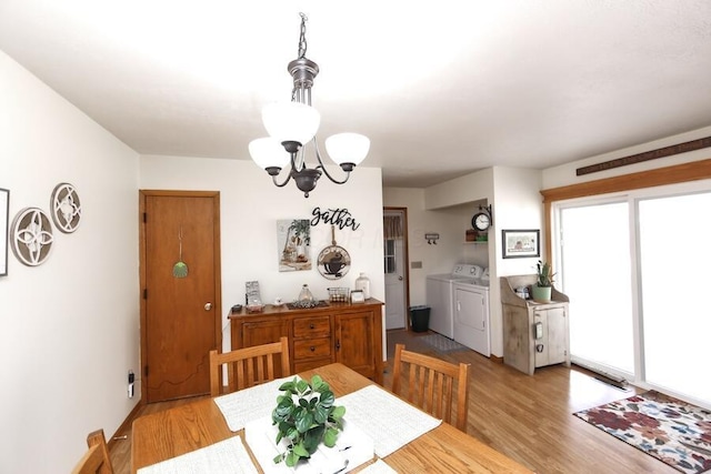 dining room with light wood-style flooring, an inviting chandelier, and washing machine and dryer