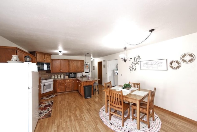 dining room with light wood-type flooring and a chandelier