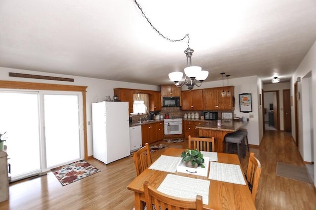 dining area featuring light wood-style floors and a chandelier