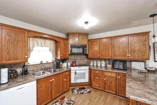 kitchen featuring decorative backsplash, white appliances, brown cabinets, and a sink