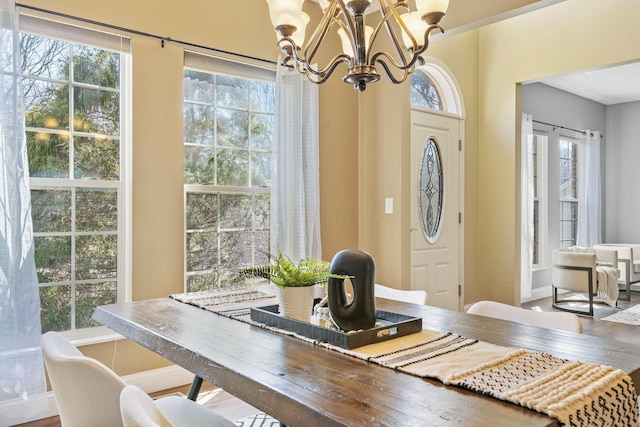 dining area with baseboards and an inviting chandelier