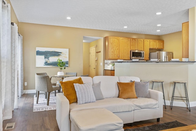 living room with dark wood-type flooring, recessed lighting, and baseboards