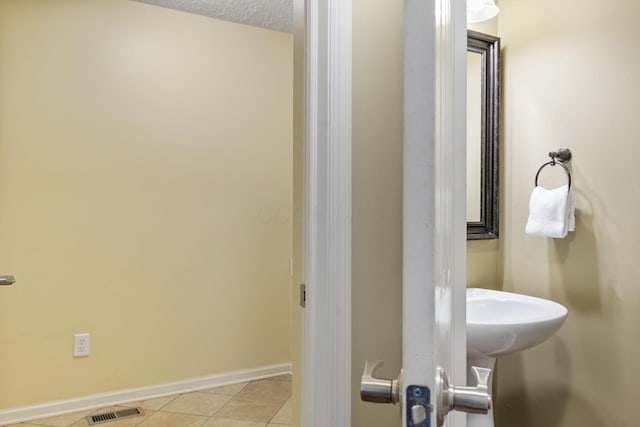 bathroom with visible vents, baseboards, and tile patterned flooring