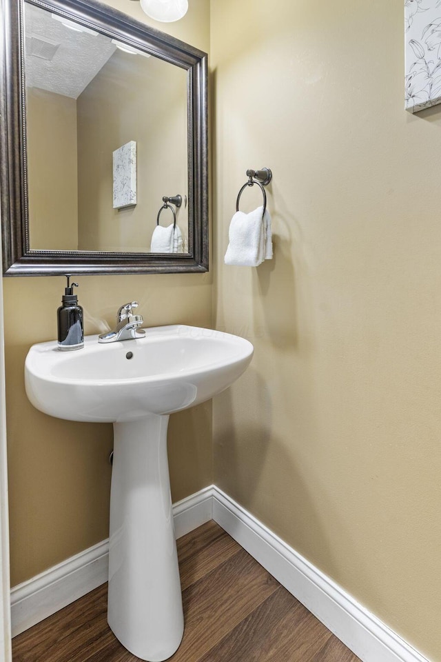 bathroom with baseboards and wood finished floors