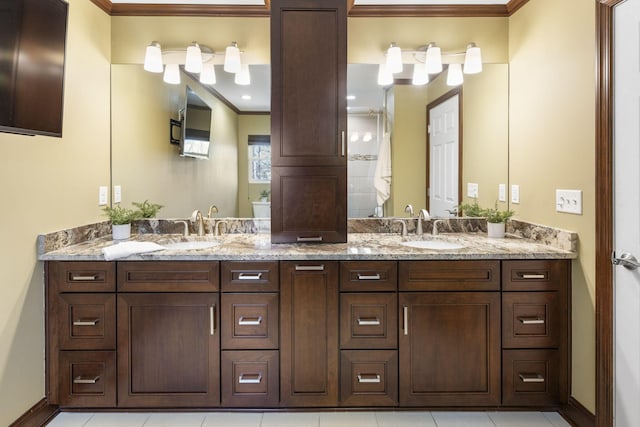 full bathroom with double vanity, ornamental molding, and a sink