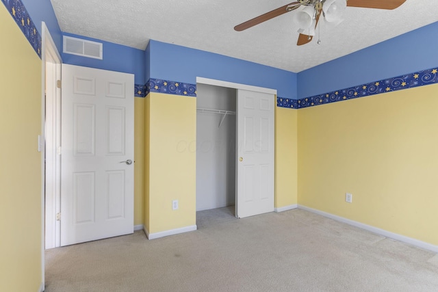 unfurnished bedroom with visible vents, carpet floors, a textured ceiling, and a closet