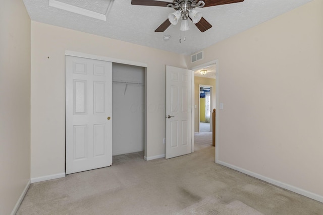 unfurnished bedroom featuring carpet flooring, visible vents, a closet, and a textured ceiling