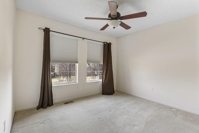 spare room featuring visible vents, ceiling fan, baseboards, and carpet