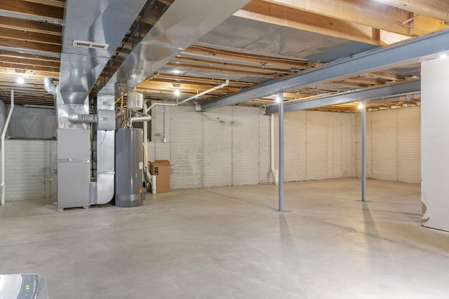 unfinished basement featuring water heater, heating unit, brick wall, and visible vents