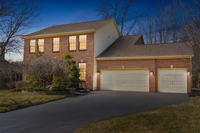 exterior space featuring aphalt driveway, an attached garage, brick siding, and roof with shingles