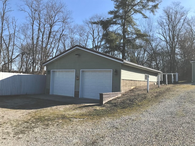 detached garage featuring fence