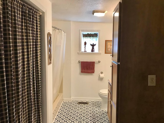 bathroom with tile patterned floors, toilet, a textured ceiling, a shower with shower curtain, and baseboards