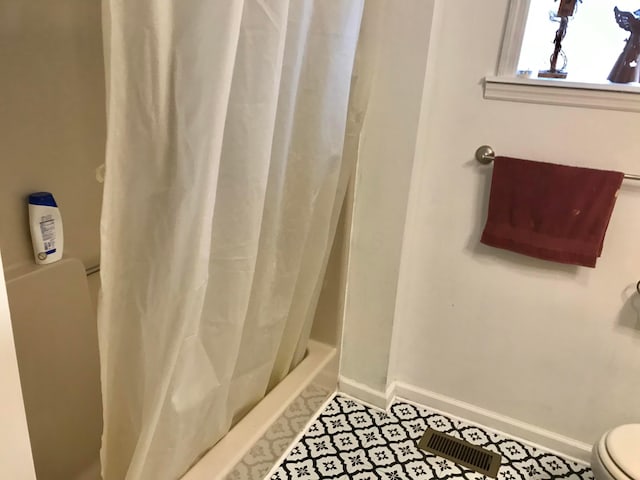 bathroom featuring tile patterned flooring, toilet, baseboards, and visible vents