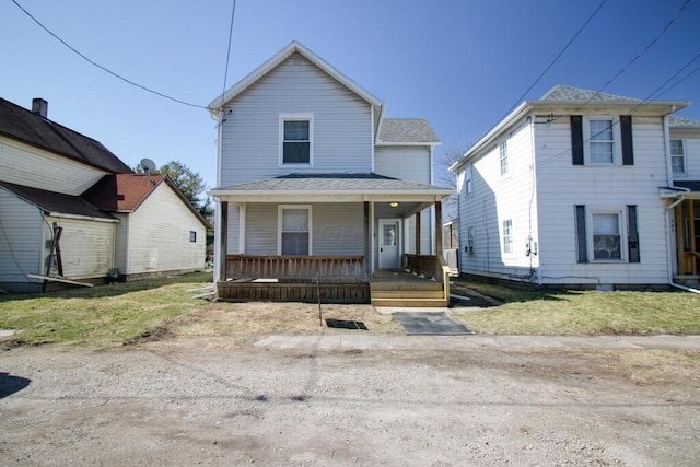 view of front facade featuring roof with shingles and a porch