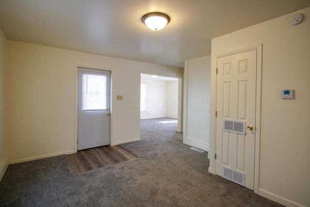 entryway featuring visible vents, baseboards, and carpet