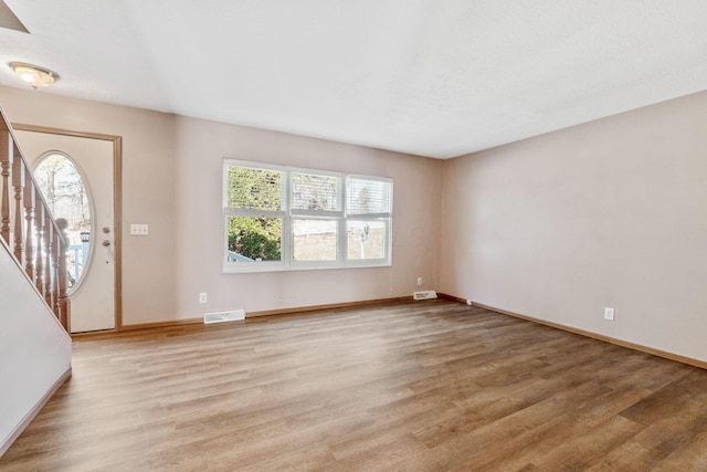 foyer featuring visible vents, baseboards, and light wood-style flooring