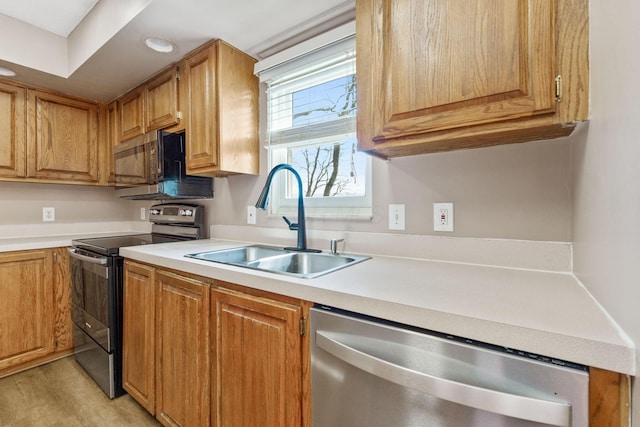 kitchen featuring a sink, light countertops, recessed lighting, and stainless steel appliances