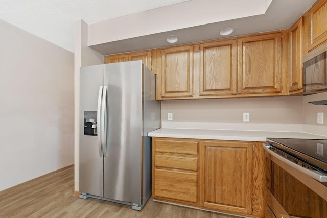 kitchen featuring light countertops, light wood-type flooring, and appliances with stainless steel finishes