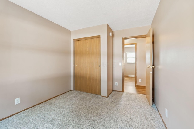 unfurnished bedroom with a closet, baseboards, and carpet