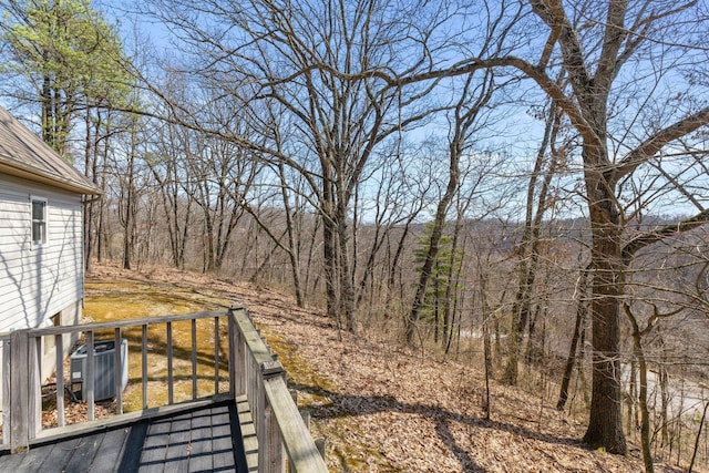 view of yard featuring central air condition unit and a forest view