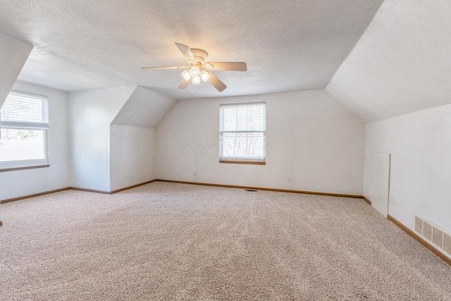 bonus room with visible vents, carpet, and a textured ceiling