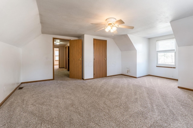 additional living space with baseboards, carpet, a ceiling fan, and vaulted ceiling