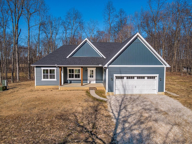 view of front of home with a garage, roof with shingles, covered porch, and driveway