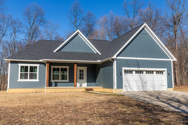 view of front facade with gravel driveway, a porch, a garage, and a shingled roof