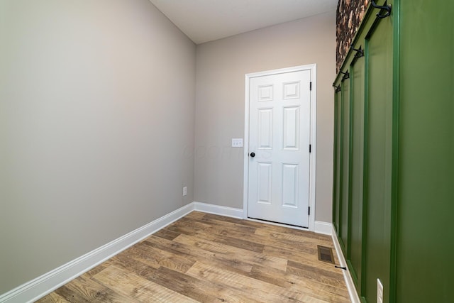 unfurnished room featuring visible vents, light wood-type flooring, and baseboards