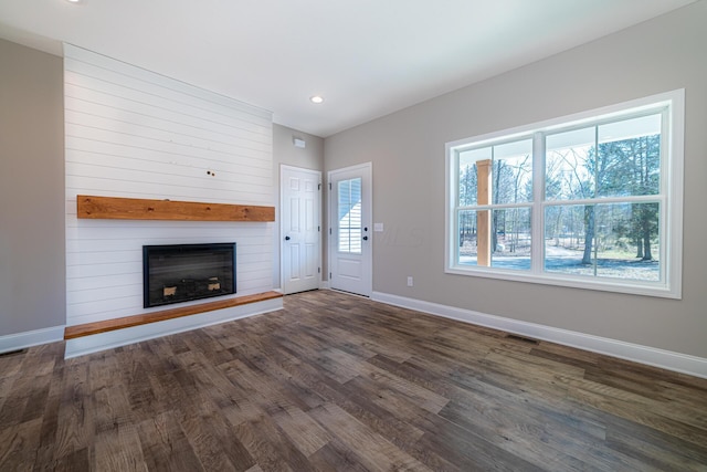 unfurnished living room with visible vents, a large fireplace, baseboards, recessed lighting, and dark wood-style floors