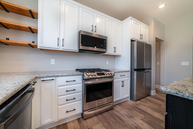 kitchen with open shelves, appliances with stainless steel finishes, dark wood-style floors, and white cabinets